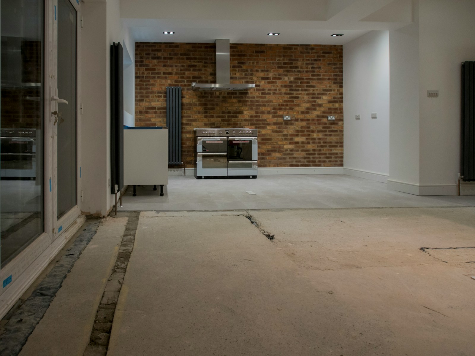 An empty room with a brick wall and a stove